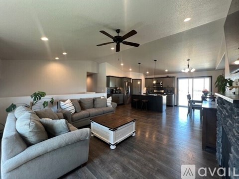 A spacious living room with a grey couch and a coffee table.