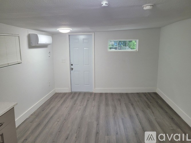 A room with a white door and a window with blinds.