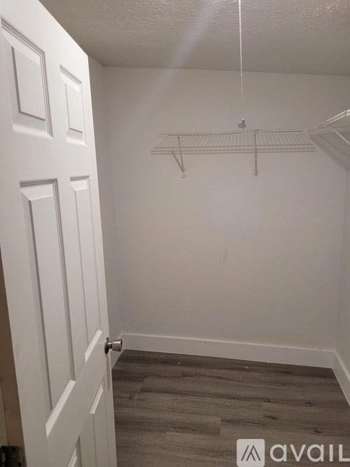 A white door with a white interior wall and a white shelf above it.