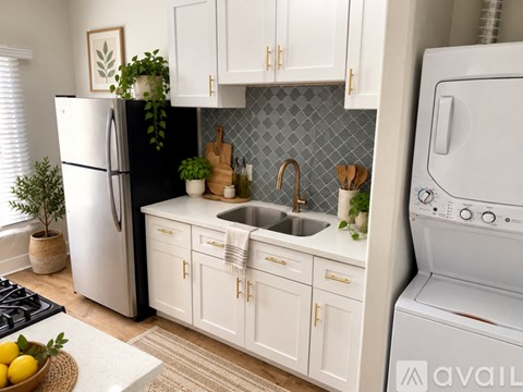 A kitchen with white cabinets and a black refrigerator.
