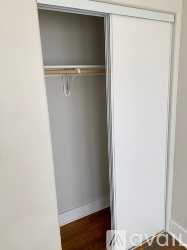 A white closet with a shelf and a hanger.