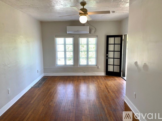 A room with wooden floors and a ceiling fan.