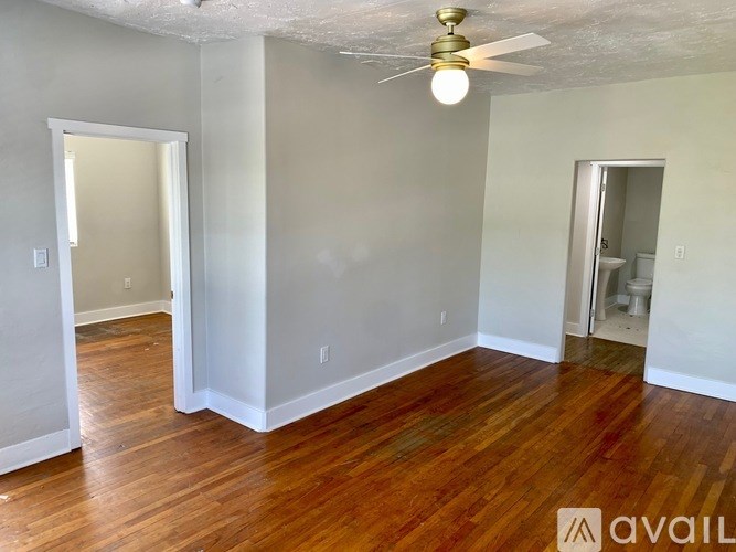 A room with wooden floors and a ceiling fan.