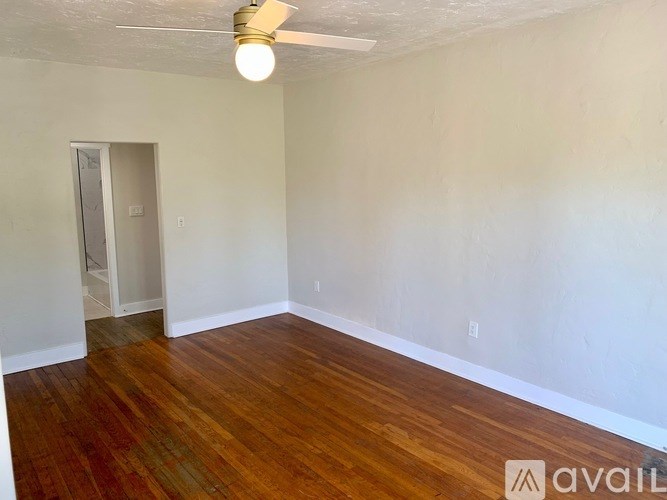 A room with wooden flooring and a ceiling fan.