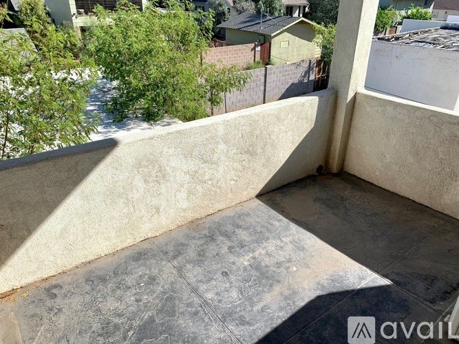 A balcony with a concrete floor and walls.