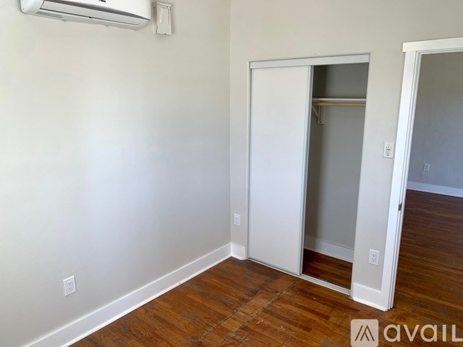 A room with a white door and a wall-mounted air conditioner.