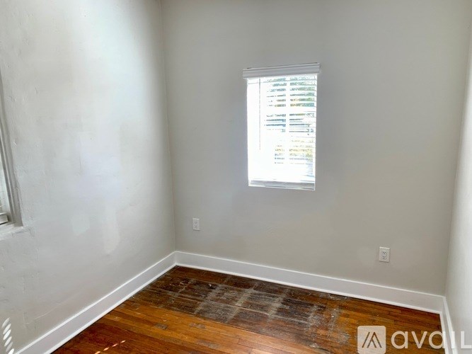 A room with a window and wooden floor.