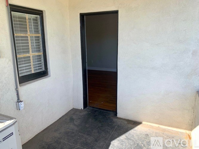 A room with a closed door, a window, and a wall socket.