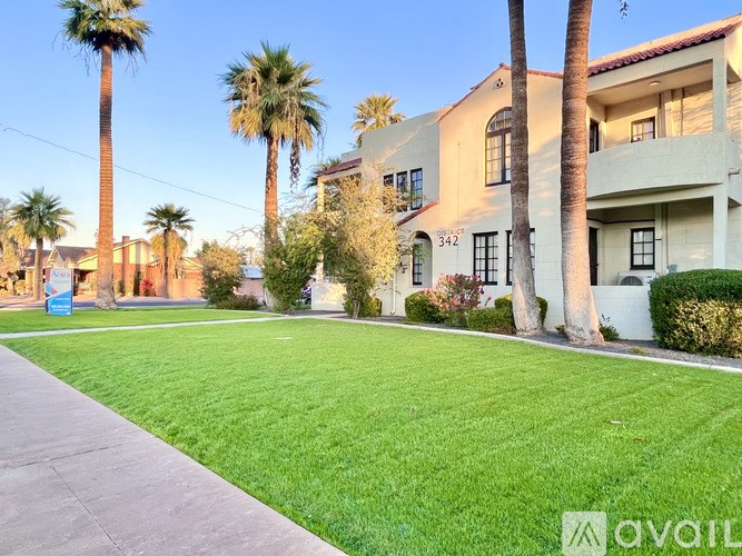 A house numbered 342 is surrounded by green grass and palm trees.