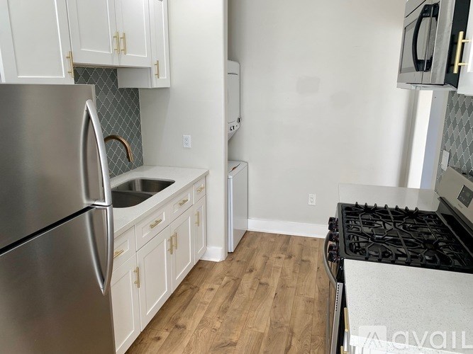 A kitchen with a stainless steel refrigerator and wooden floors.