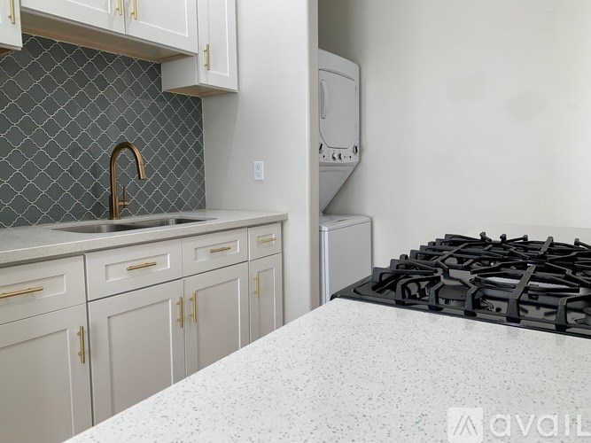 A kitchen with a black gas stove top and white countertop.