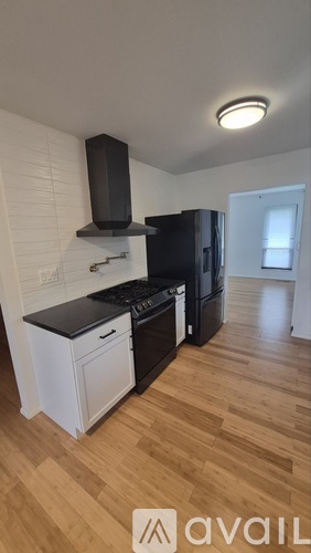 A kitchen with black appliances and white cabinetry.