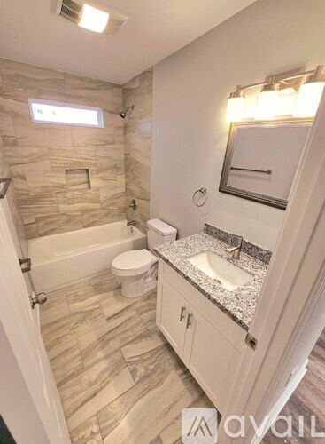 A bathroom with a stone wall and a white toilet.
