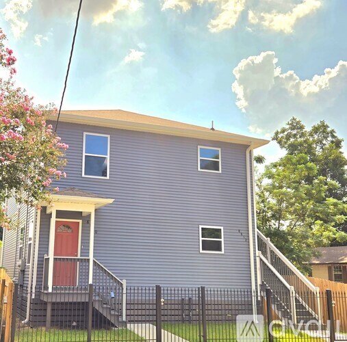 A house with a red door and a small porch.