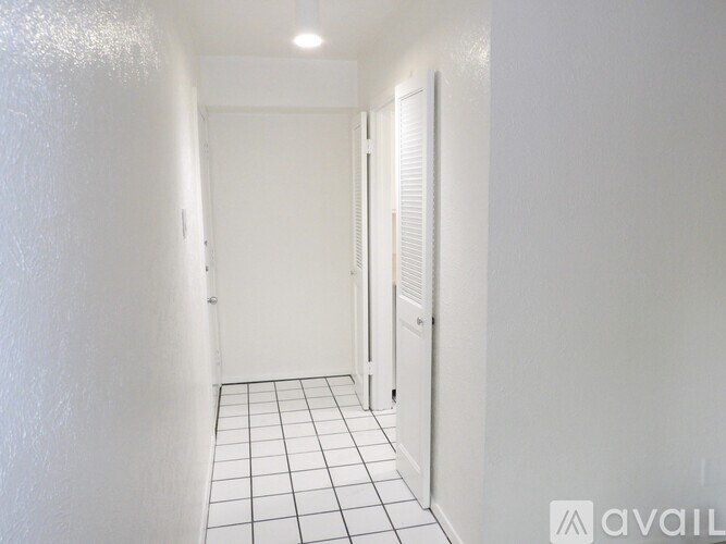 A room with wooden flooring and a doorway leading to another room.