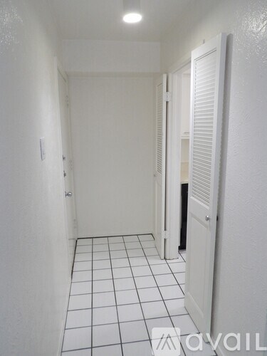 A long white hallway with a tiled floor.