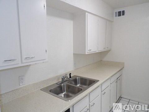A kitchen with white cabinets and a sink.