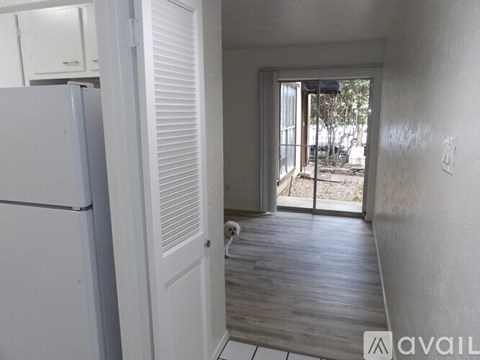 A room with wooden flooring and a window with blinds.