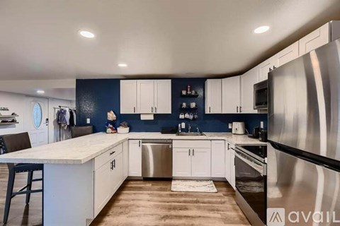 A modern kitchen with a stainless steel refrigerator and white countertops.