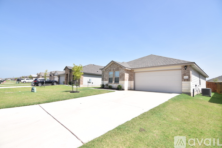 A house with a garage and a driveway in front of it.