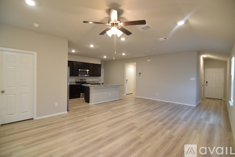 A spacious room with a ceiling fan and lighting fixtures.