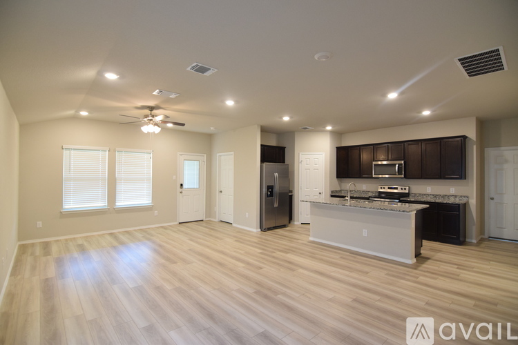 A spacious kitchen with a refrigerator, sink, and stove is available for rent.