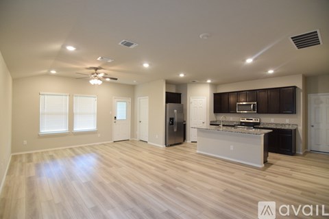 A spacious kitchen with a refrigerator, sink, and stove is available for rent.