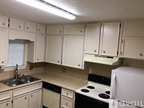 A kitchen with white cabinets and a black stove top.