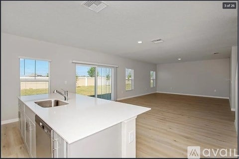 A kitchen with white countertops and a sink is shown.