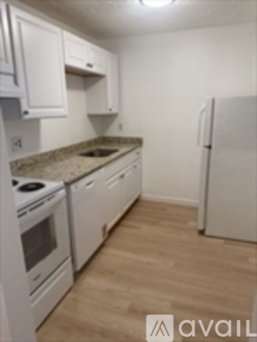 A kitchen with white appliances and cabinets.