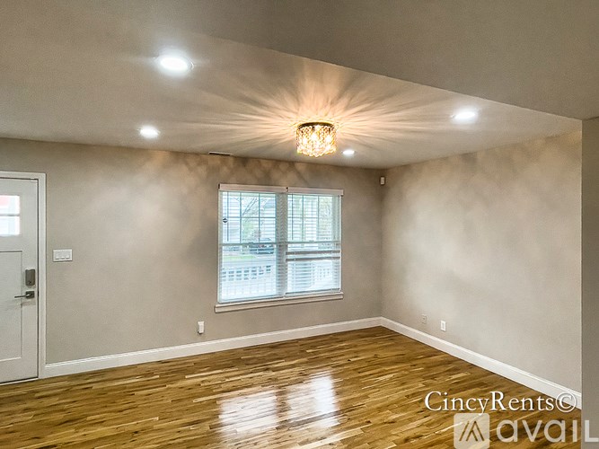 A room with a wooden floor and a chandelier hanging from the ceiling.
