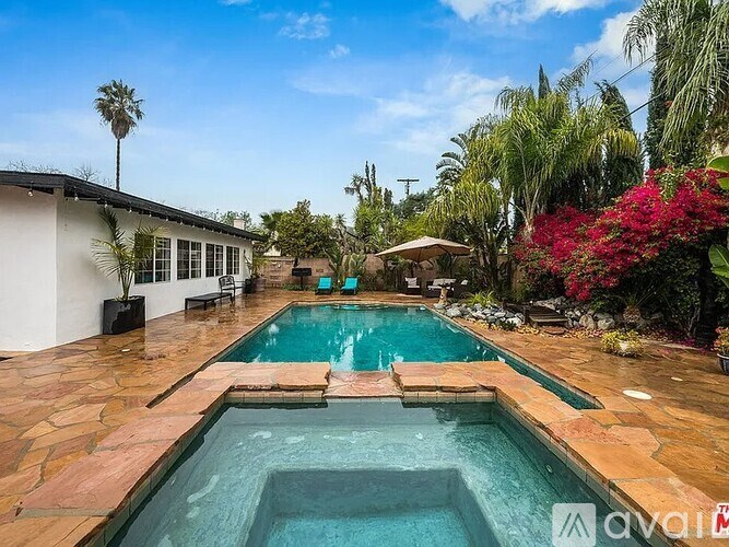 A pool surrounded by a patio and a house.