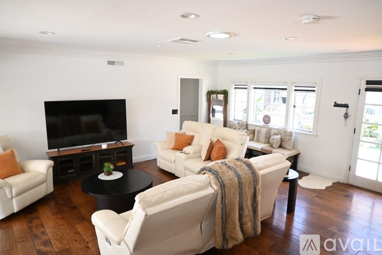 A kitchen with a black granite countertop and wooden floors.