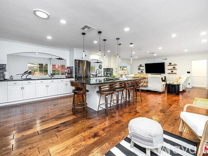A modern kitchen with a bar and seating area.