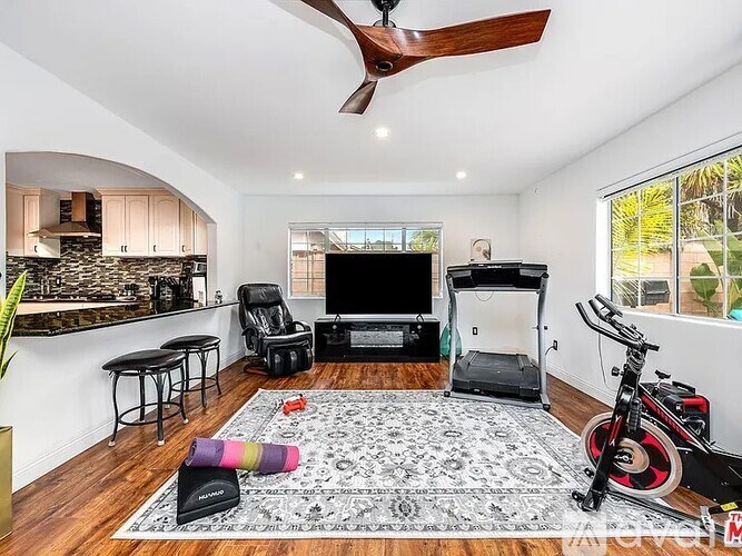 A living room with a television, a fireplace, and a bicycle.