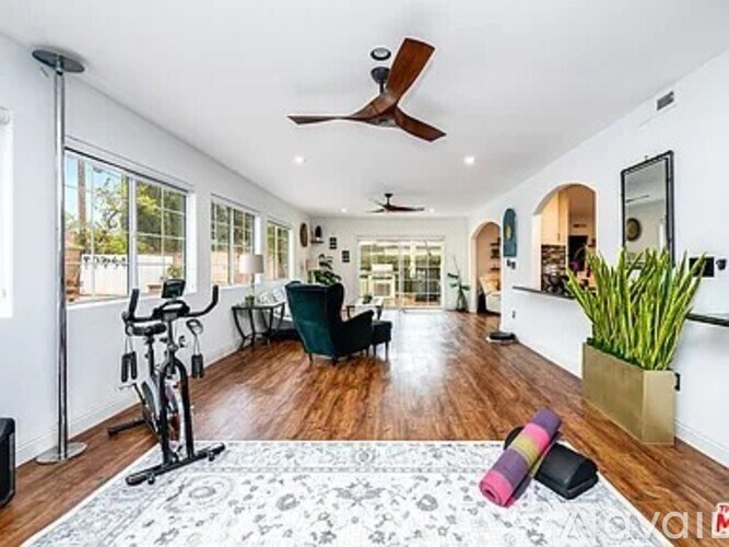 A spacious living room with a bicycle and a rug on the floor.