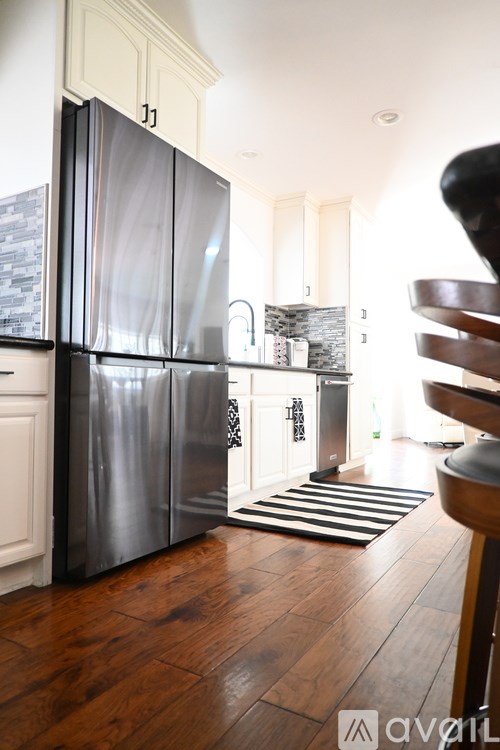 A bedroom with a large bed, a television, and a sliding glass door leading to a balcony.