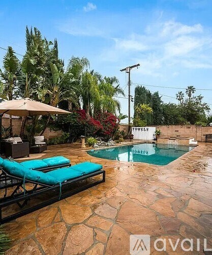 A pool with a sun lounger and a towel hanging on a line.