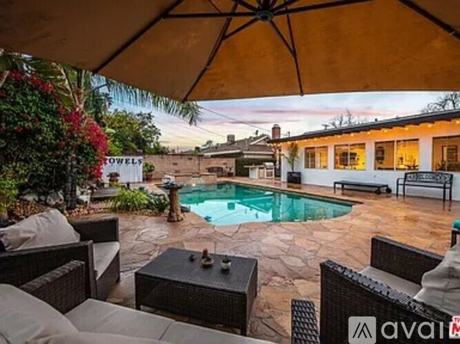 A patio with a table and chairs and a pool.