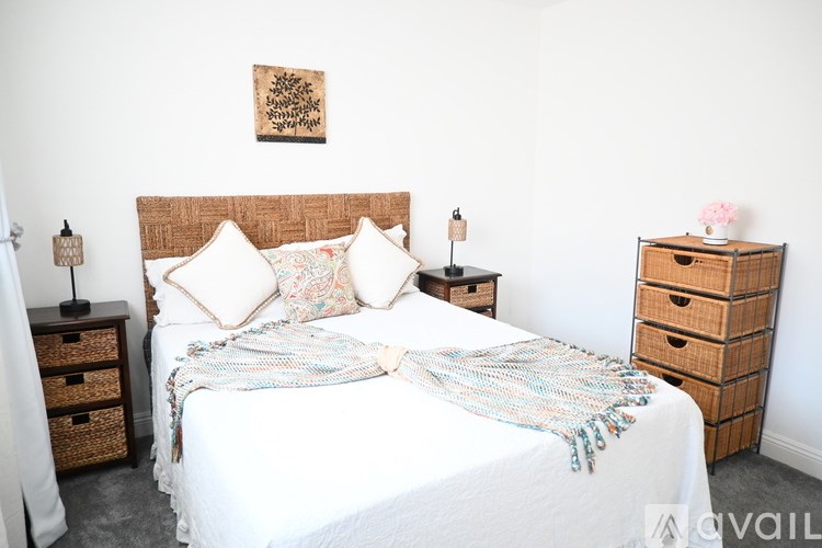 A bedroom with a white bed and a wooden headboard.