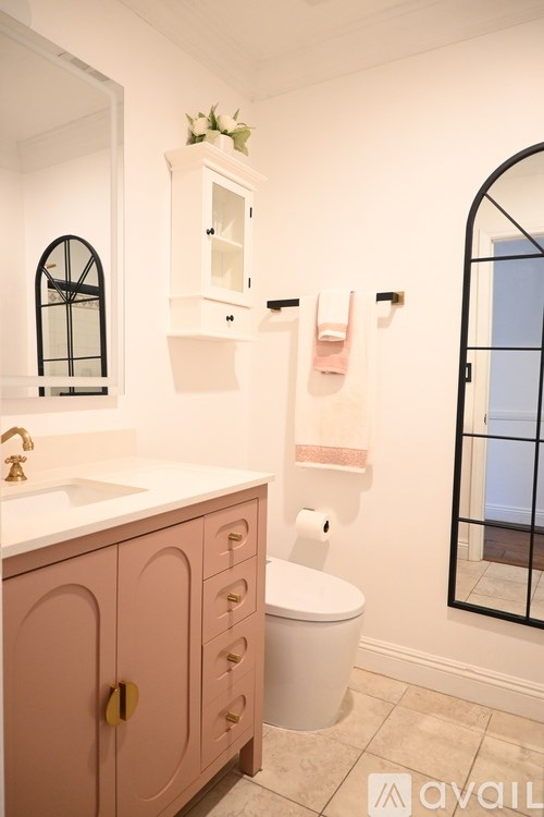 A bathroom with a sink, toilet and a mirror.