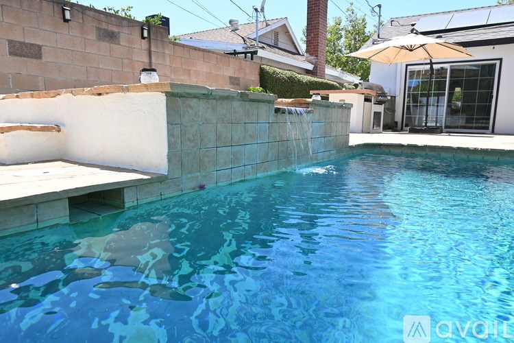 A pool with a waterfall feature in the middle of it.