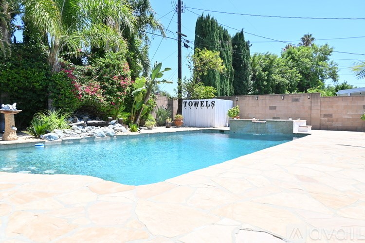 A pool surrounded by a stone wall with a sign that says "TOWELS".