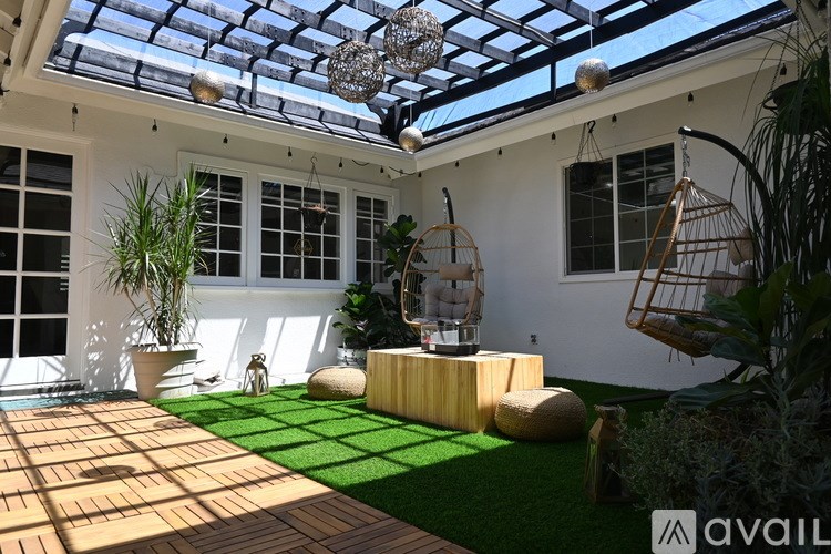 A white house with a black roof and a green lawn in front.