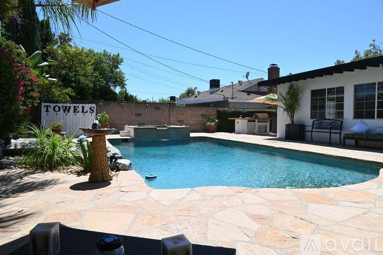 A pool surrounded by a stone patio and a sign that says "TOWELS".