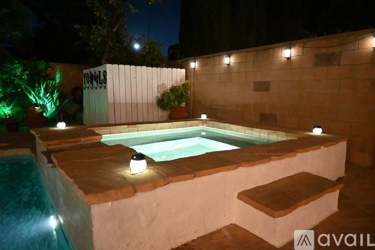 A hot tub is surrounded by lights and steps.