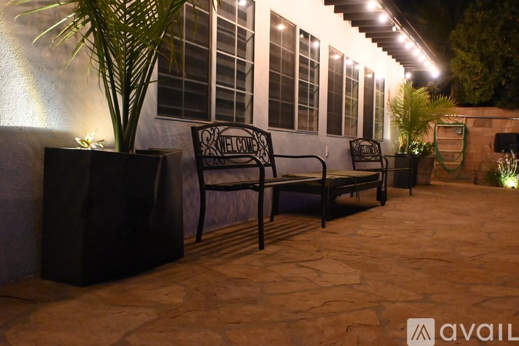 A patio with a bench and a plant.
