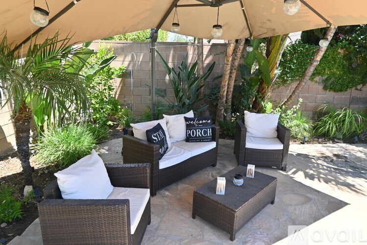 A patio with a couch and a table under a canopy.