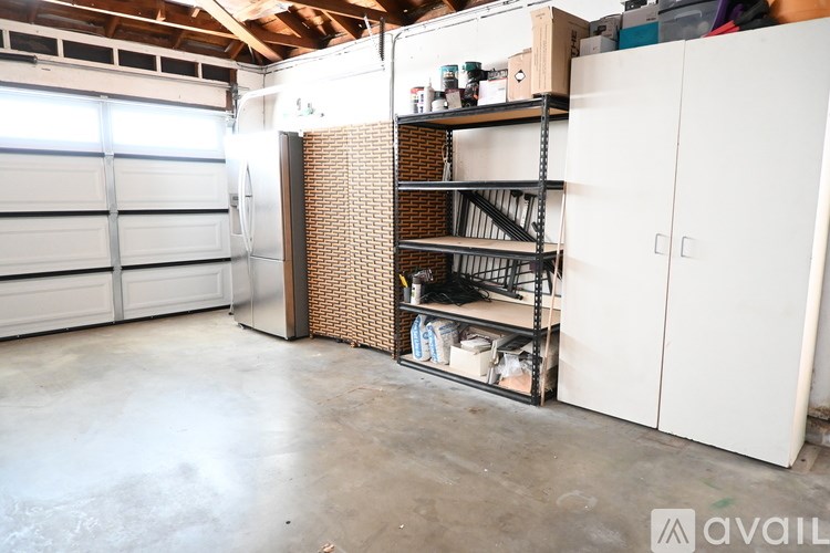 A storage room with a white door and shelves filled with boxes and other items.
