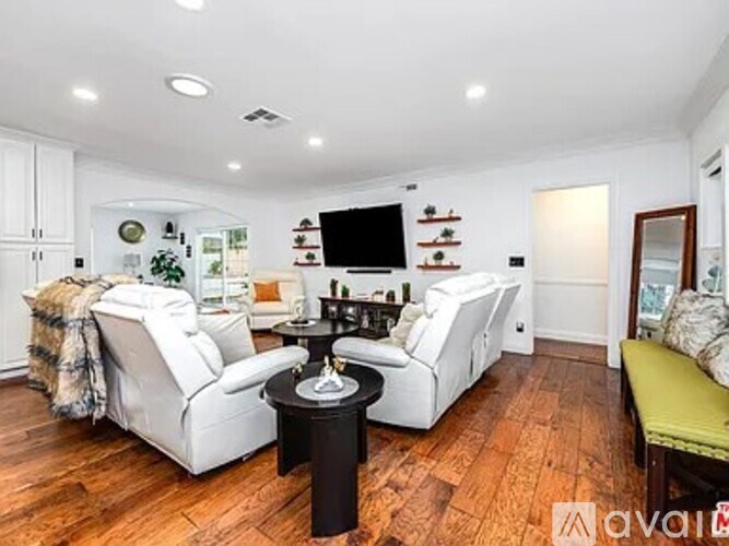 A living room with a white couch and a black coffee table.